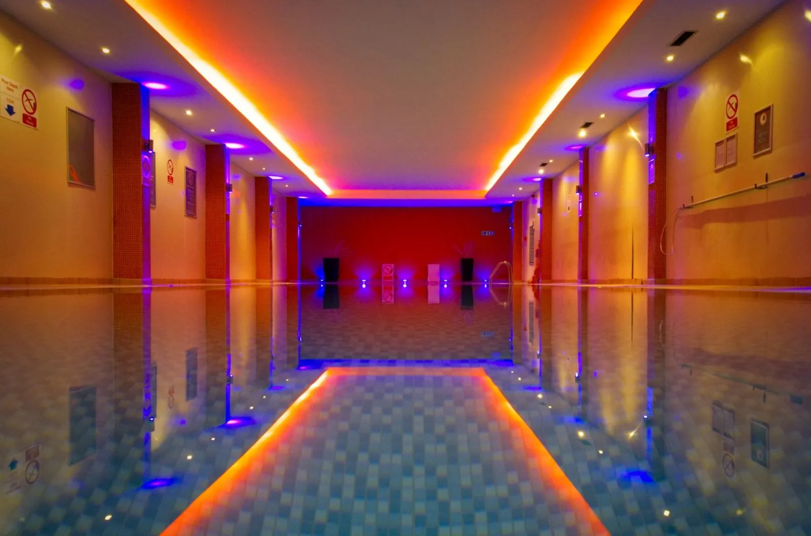 The indoor pool at Gold's Gym Hanwell, under orange and blue lights