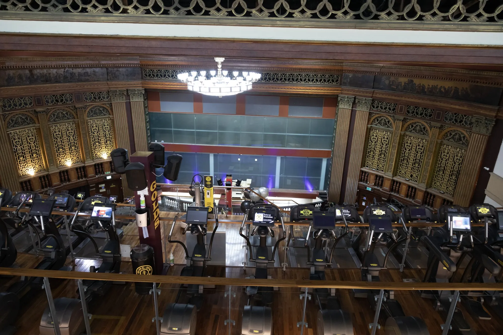 Indoor cycling bikes in the old auditorium, under a chandelier