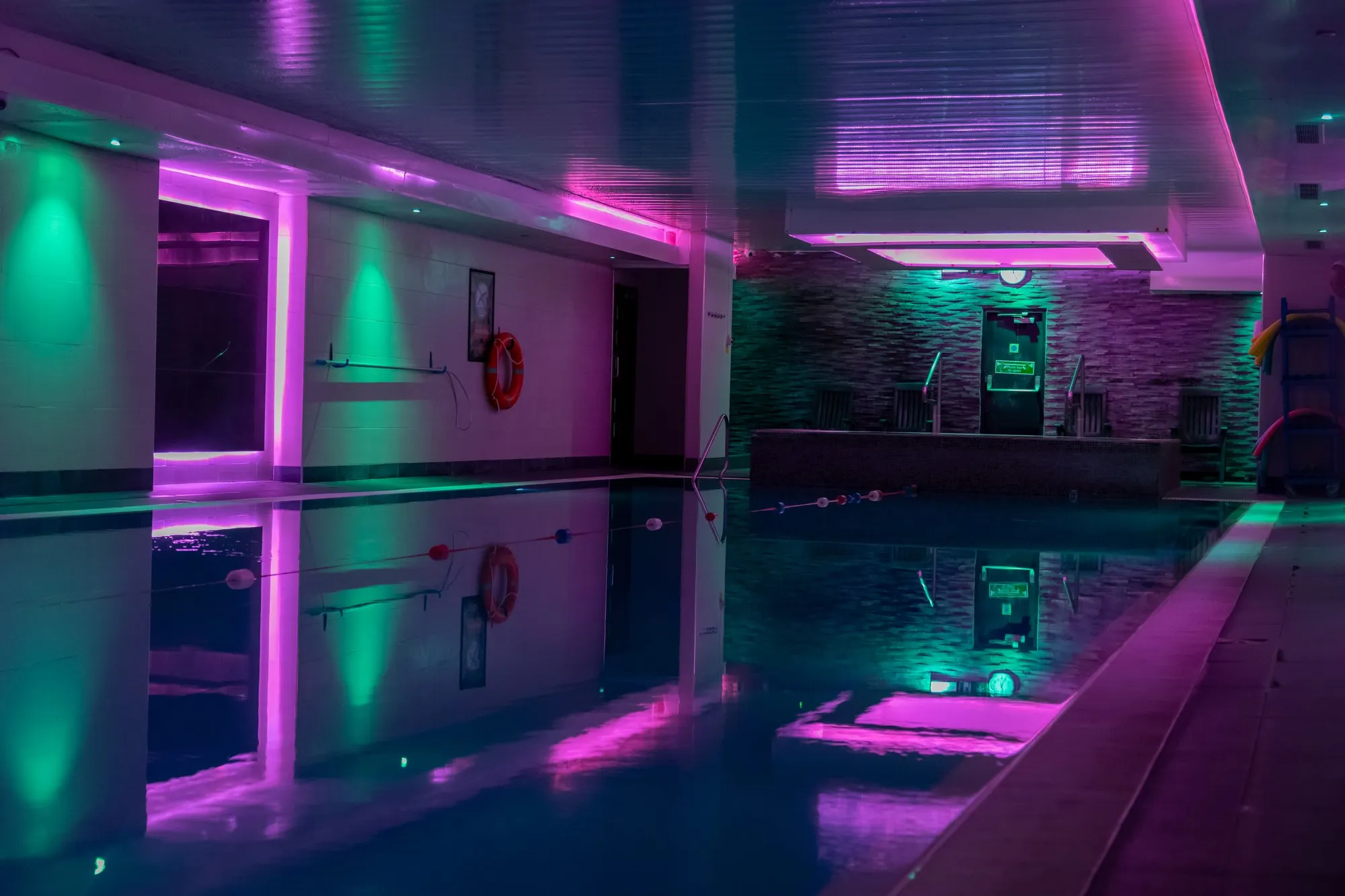 The indoor pool under green and pink lights, Gold's Gym Hounslow